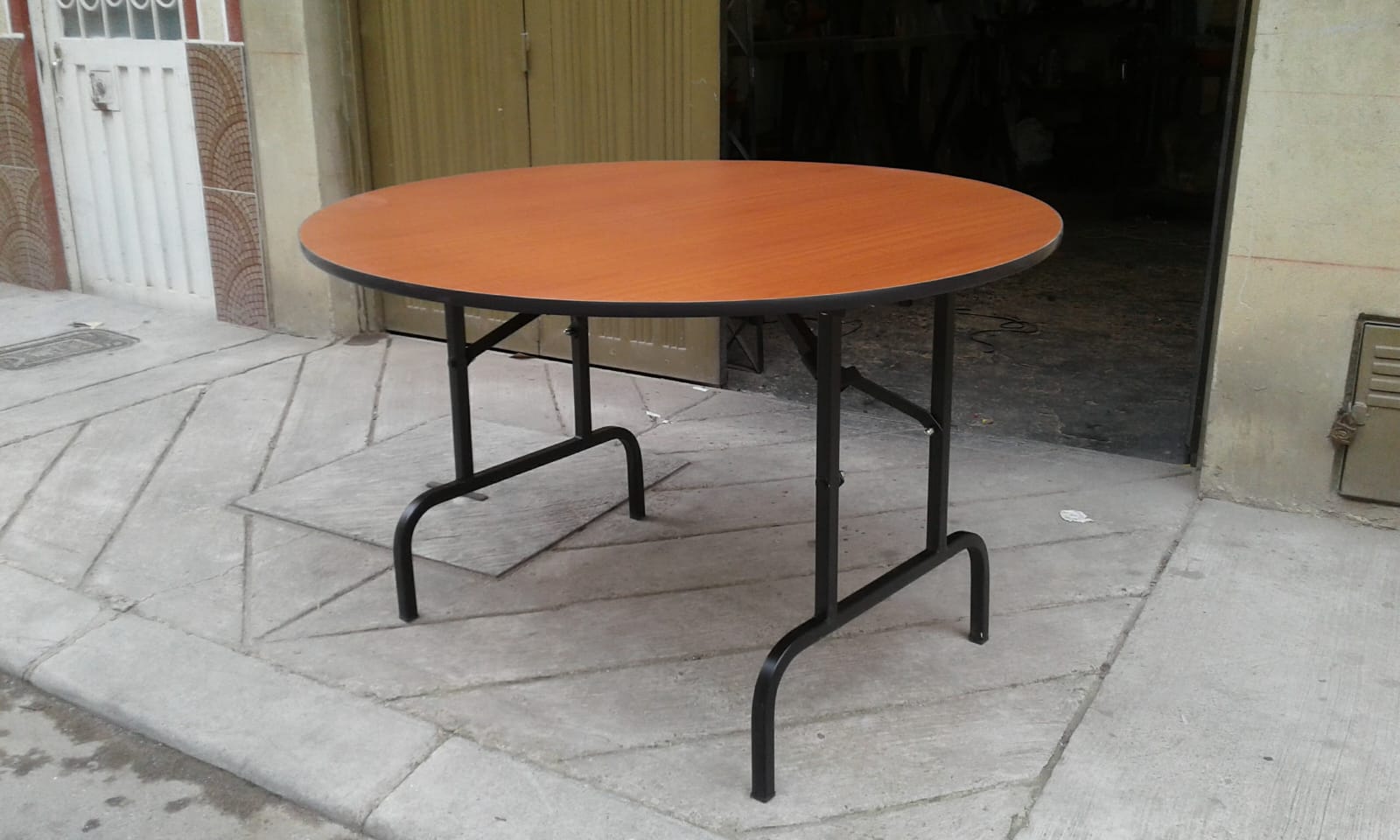 Mesa redonda plegable con cubierta en madera tono caoba